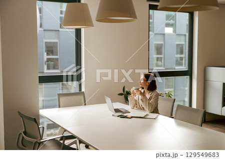 A contemplative professional is immersed in their work in a modern office setting 129549683