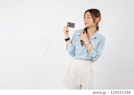 Happy asian woman hold credit card pointing finger, bank card solution, lady card concept showing benefits and money alternatives with debit card, isolated studio white background Happy asian woman hold credit card pointing finger, bank card solution, lady card concept showing benefits and money alternatives with debit card, isolated studio white background 129551198