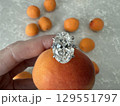 Diamond engagement ring placed on top of fresh apricot 129551797