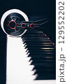 studio headphone on piano keys on black background 129552202