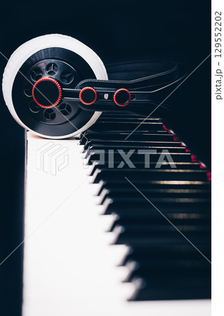 studio headphone on piano keys on black background 129552202