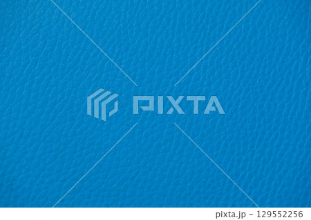 Close-up of vibrant blue faux leather texture, forming an abstract background suitable for upholstery, fashion design, and digital wallpaper concepts 129552256
