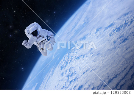 Astronaut at spacewalk. Spaceman and Earth. Space scene. 129553008