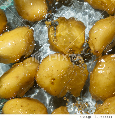 Raw Potatoes In Water Splash Macro Top View. 129553334