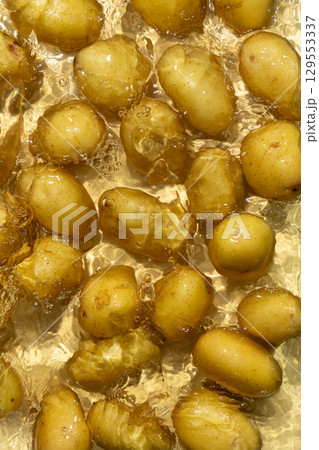 Whole Organic Raw Potatoes In Water Top View, Splash And Ripples. Whole Organic Raw Potatoes In Water Top View, Splash And Ripples. 129553337