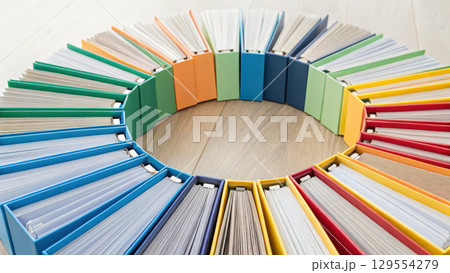 Colorful binders arranged in circular pattern symbolize organization and creativity in context of health insurance concept 129554279