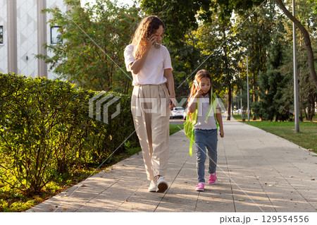 Mother and child walking on a sunny day in the park 129554556