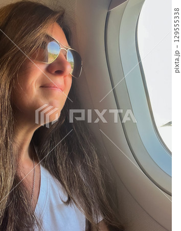 Relaxed and happy female traveler gazing at clouds and landscapes. Vertical shot Relaxed and happy female traveler gazing at clouds and landscapes. Vertical shot 129555338