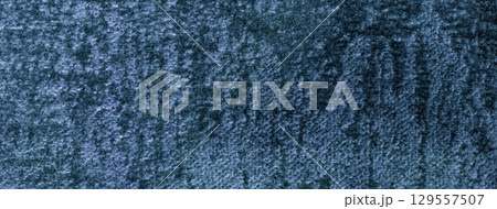Navy blue fluffy background of soft shiny velour fabric, macro. Texture of dark denim velvet textile backdrop 129557507