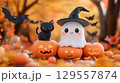 Adorable halloween scene with ghost and black cat surrounded by pumpkins for autumn decoration 129557874