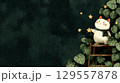 Whimsical cat reaches for stars on ladder in leafy night garden 129557878