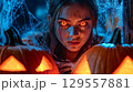 Spooky halloween scene with creepy glowing eyed character and pumpkins 129557881