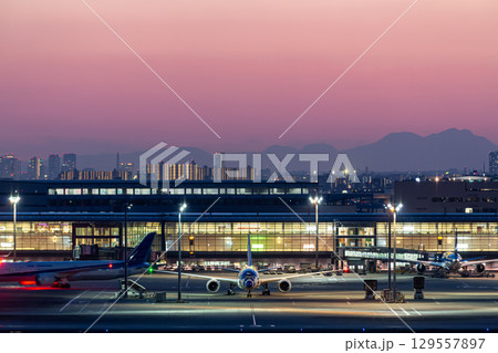 夜の空港ターミナルと駐機する旅客機 129557897