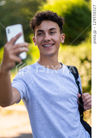 Smiling dark-haired teen making selfie and feeling excited 129558327