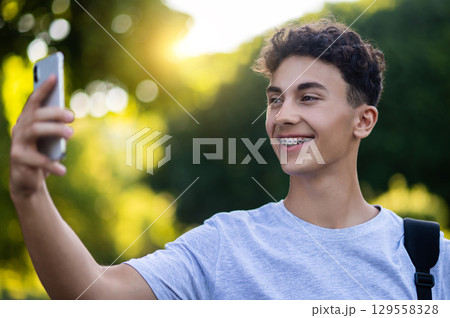 Smiling dark-haired teen making selfie and feeling excited Smiling dark-haired teen making selfie and feeling excited 129558328