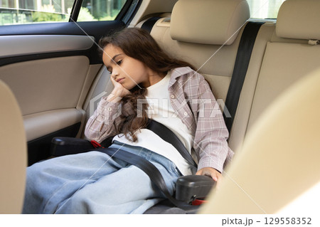 Cute girl waiting for her mom in the car and looking bored Cute girl waiting for her mom in the car and looking bored 129558352