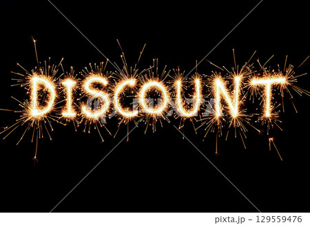 Sparkling letters display word discount illuminated against a black background during a celebration event 129559476