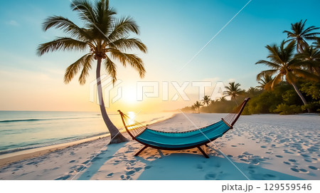 Beautiful beach with hammock under palm trees during sunset at a tropical location Beautiful beach with hammock under palm trees during sunset at a tropical location 129559546