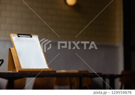 On the table there is a wooden stand with a tablet with sheets 129559876