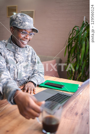 Smiling african american soldier working from home taking a coffee break 129560124