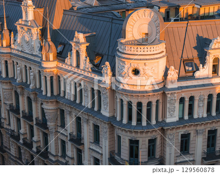 Art Nouveau building in Riga, Latvia, with sculpted figures, Alberta street, ornate columns, and dormer windows, illuminated by warm sunset light. Art Nouveau building in Riga, Latvia, with sculpted figures, Alberta street, ornate columns, and dormer windows, illuminated by warm sunset light. 129560878