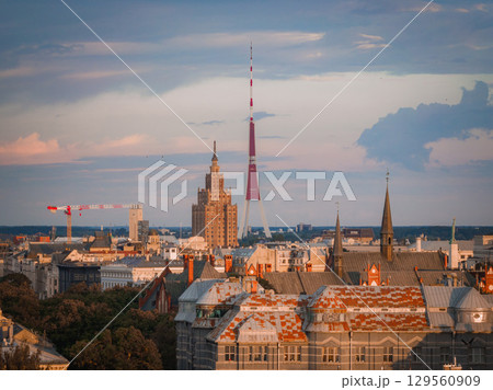 Riga, Latvia skyline at sunset with the Riga TV Tower, Jugendstil rooftops, spires, and the Latvian Academy of Sciences building in view. Riga, Latvia skyline at sunset with the Riga TV Tower, Jugendstil rooftops, spires, and the Latvian Academy of Sciences building in view. 129560909