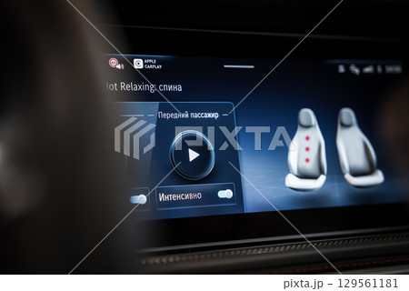 Infotainment screen in a high end vehicle shows massage seat controls in Russian, Apple CarPlay logo, and highlighted seat massage areas. Infotainment screen in a high end vehicle shows massage seat controls in Russian, Apple CarPlay logo, and highlighted seat massage areas. 129561181