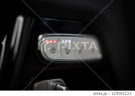 Illuminated seat heating and cooling controls with polished finish, likely from a Mercedes AMG G Class, set against a dark background. 129561221