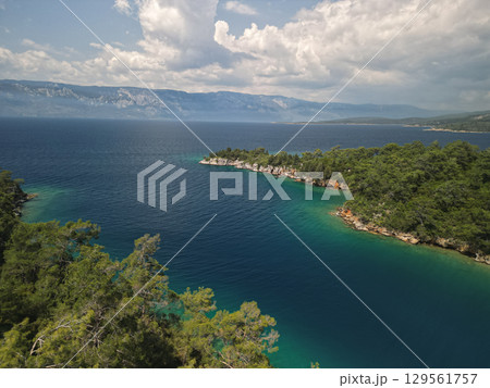 curving cove with pine cliffs and deep blue water in gokova bay, mugla, Turkey curving cove with pine cliffs and deep blue water in gokova bay, mugla, Turkey 129561757