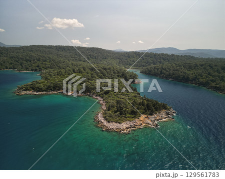 Aerial view of rocky headland dividing two turquoise bays, Mugla, Turkey Aerial view of rocky headland dividing two turquoise bays, Mugla, Turkey 129561783