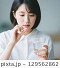 薬をつまんで飲もうとしている日本人女性 129562862