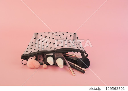 Pastel backdrop: makeup bag with brushes and cosmetics Pastel backdrop: makeup bag with brushes and cosmetics 129562891