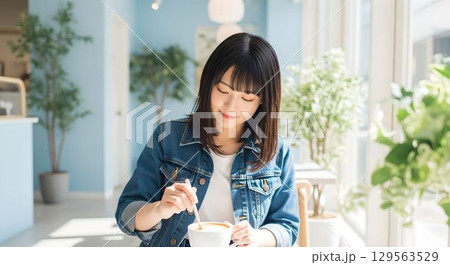 カフェでカフェオレを混ぜる日本人女性　AI生成画像 129563529