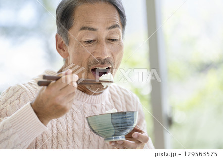 ごはんを食べる60代の男性 ごはんを食べる60代の男性 129563575