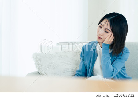 リビングで悩む若い女性 129563812
