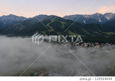 夏の早朝の雲海に透ける白馬村の街並みと白馬連峰 長野県白馬村(ドローンによる空撮) 夏の早朝の雲海に透ける白馬村の街並みと白馬連峰 長野県白馬村(ドローンによる空撮) 129564649