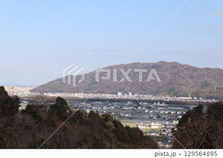 緑に包まれた高台から望む都市と山々 — 自然と都市が共存する風景 緑に包まれた高台から望む都市と山々 — 自然と都市が共存する風景 129564895