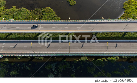 High angle view of a car driving on the bridge for crossing Nong Luang the largest lake in Chiang Rai province of Thailand.  129564906