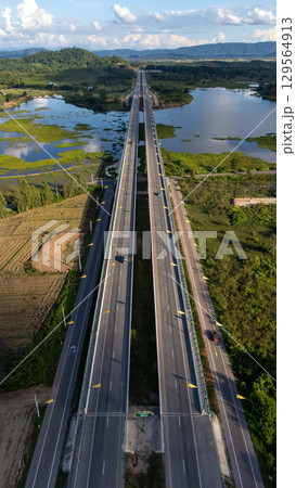 Aerial view of the long bridge build for crossing Nong Luang the largest lake in Wiang Chai district of Chiang Rai province of Thailand. 129564913