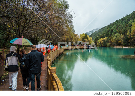 Lakeside Path and Tourists with Umbrellas in Blue Moon Valley, Lijiang, China Lakeside Path and Tourists with Umbrellas in Blue Moon Valley, Lijiang, China 129565092