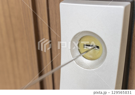 玄関ドアの鍵穴にスプレーで潤滑剤を入れるイメージ 129565831