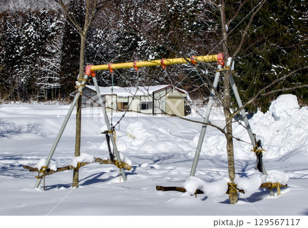雪に埋もれた公園の遊具が使えない風景 129567117