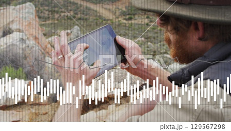 Image of data processing over caucasian male hiker with tablet in mountains 129567298