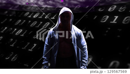Image of binary coding and data processing over male hacker in hoodie 129567569