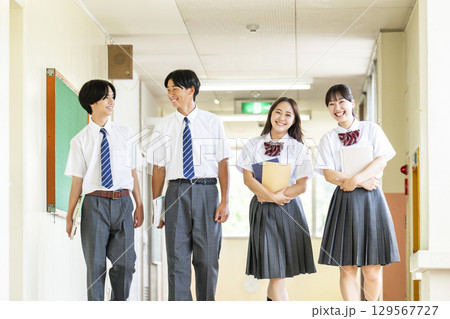 学校の廊下を歩く男女の高校生 129567727