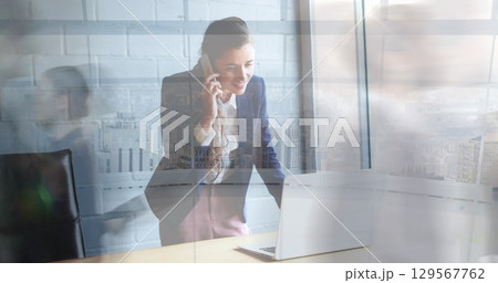 Image of caucasian businesswoman talking on cellphone over time lapse of blurred people 129567762