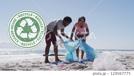 Image of recycling symbol over african american couple cleaning at beach 129567775