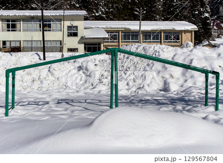 雪に埋もれた遊具と小学校の風景 雪に埋もれた遊具と小学校の風景 129567804