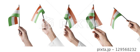 The Niger flag in hand in different angles on a white background 129568232