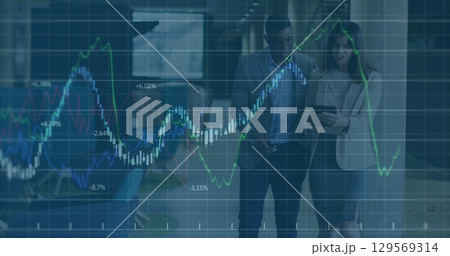 Image of graph data moving over multiracial partners discussing with tablet in office lobby 129569314